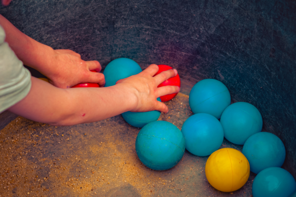 hands grabbing different colored balls