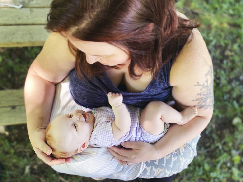 mother holding baby, getting ready to breastfeed