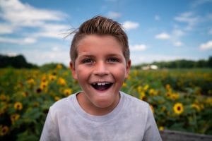 Boy in a field of sunflowers.