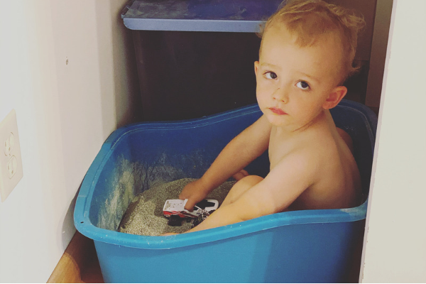Potty training toddler, what not to use. Toddler sitting in a box of kitty litter.