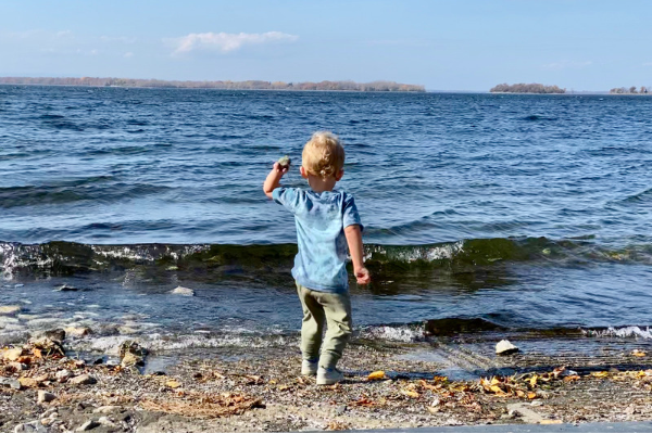 Boy throwing rocks into the lake instead of napping