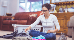 newbie homeschooler mom folds laundry while she listens to a podcast