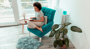 newbie homeschooler mom reading a book on a blue chair