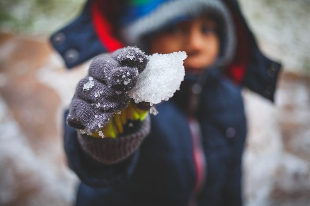 A child holds up a snowball