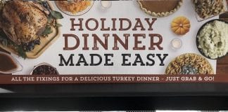 Finding New Thanksgiving Traditions in COVID Times A grocery store sign advertising easy, to-go turkey dinners with all the fixings