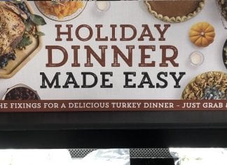 Finding New Thanksgiving Traditions in COVID Times A grocery store sign advertising easy, to-go turkey dinners with all the fixings