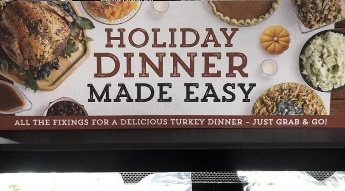 A grocery store sign advertising easy, to-go turkey dinners with all the fixings