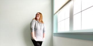 I Don’t Care if My Leggings Offend You: In Defense of my Casual Style A woman in leggings and a gray sweatersmiles