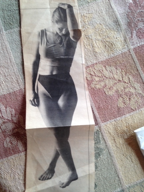 woman in a dancer's pose, looking down.