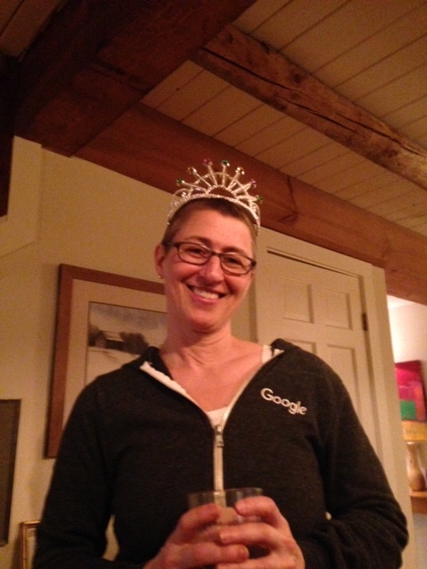 Woman with a big smile, undergoing treatment for breast cancer, hanging out at home, wearing a tiara