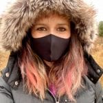 woman wearing a winter coat and a covid mask
