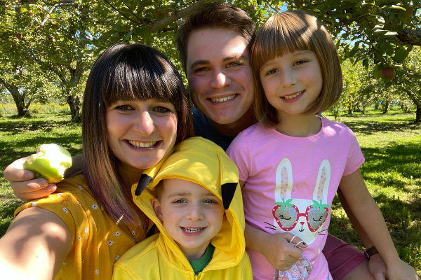 Young white family, smiling while outdoors in the summer