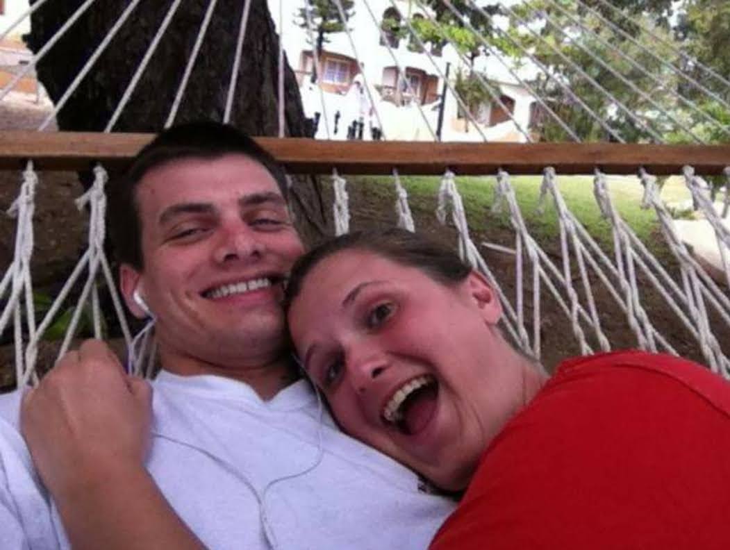 Man and woman lying in a hammock, smiling broadly