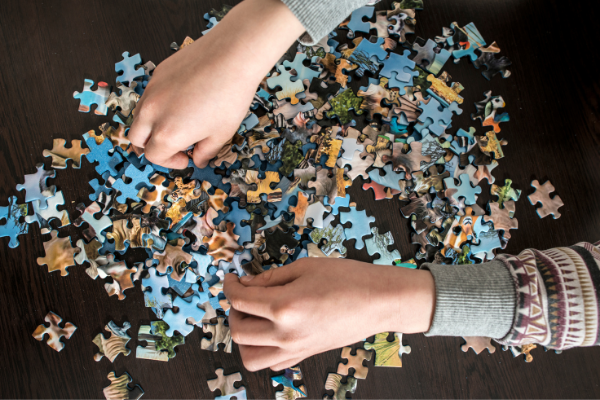 hands assembling a puzzle