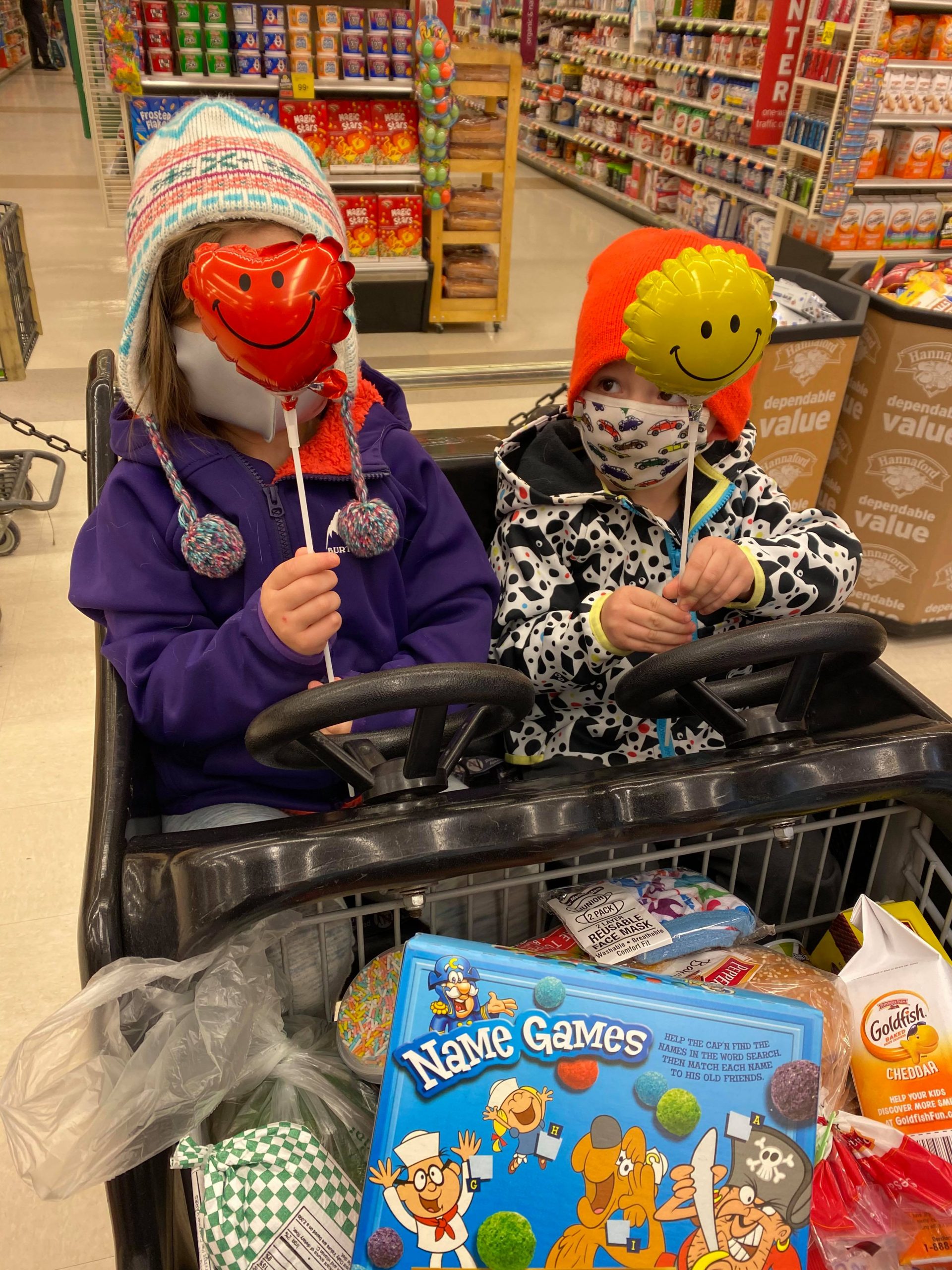 children with small heart balloons in front of their faces