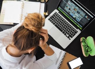 Get In The Work Zone: Five Tips to Work More Efficiently Woman working at a computer, head in hands