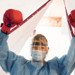 woman in medical scrubs, wearing boxing gloves