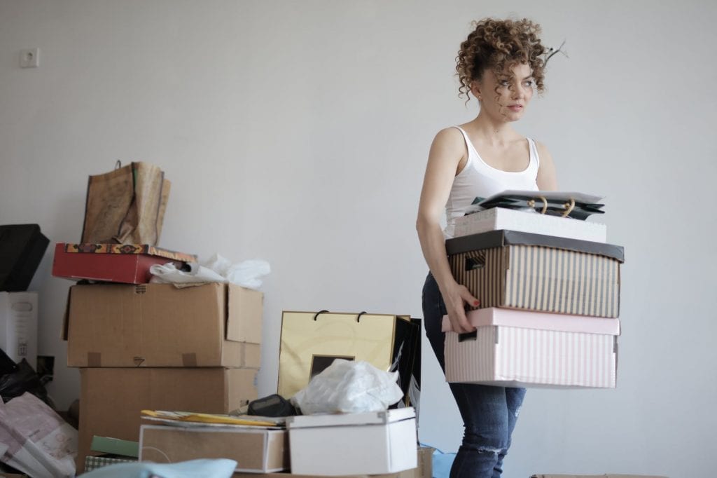 woman carrying boxes away from a pile