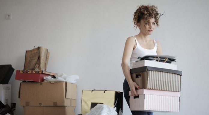 I’m a Mess: Learning the Difference Between Decluttering and Tidying Up woman carrying boxes away from a pile
