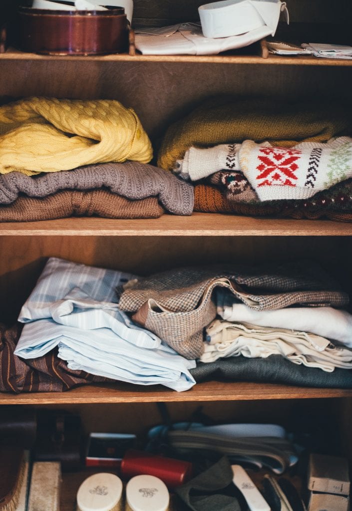 A closet of sweaters and shirts