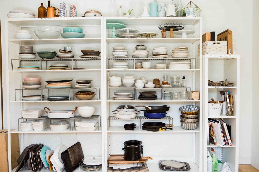 Wire kitchen shelves filled with many dishes