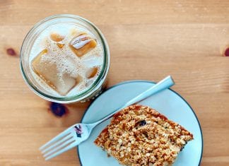 Easy Breakfast Recipe: Blueberry Oat Milk Pan Muffins Viewed from above, an iced coffee next to a plate with oat milk blueberry muffin square