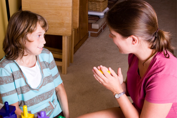 teacher explains something to child.