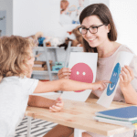 Adult teaher works with autistic child