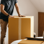 man packing a box to move