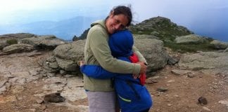 Move More and Feel Better: Is the Value of Exercise Complicated? A young boy hugs hissmiling mother at the top of a mountain.