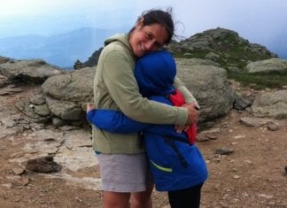 Move More and Feel Better: Is the Value of Exercise Complicated? A young boy hugs hissmiling mother at the top of a mountain.