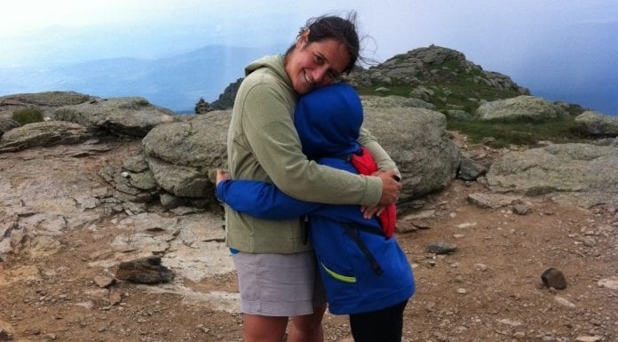 Move More and Feel Better: Is the Value of Exercise Complicated? A young boy hugs hissmiling mother at the top of a mountain.