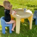 toddler eats yogurt outside