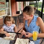 Mother and daughter playing tic tak toe at a restaurant