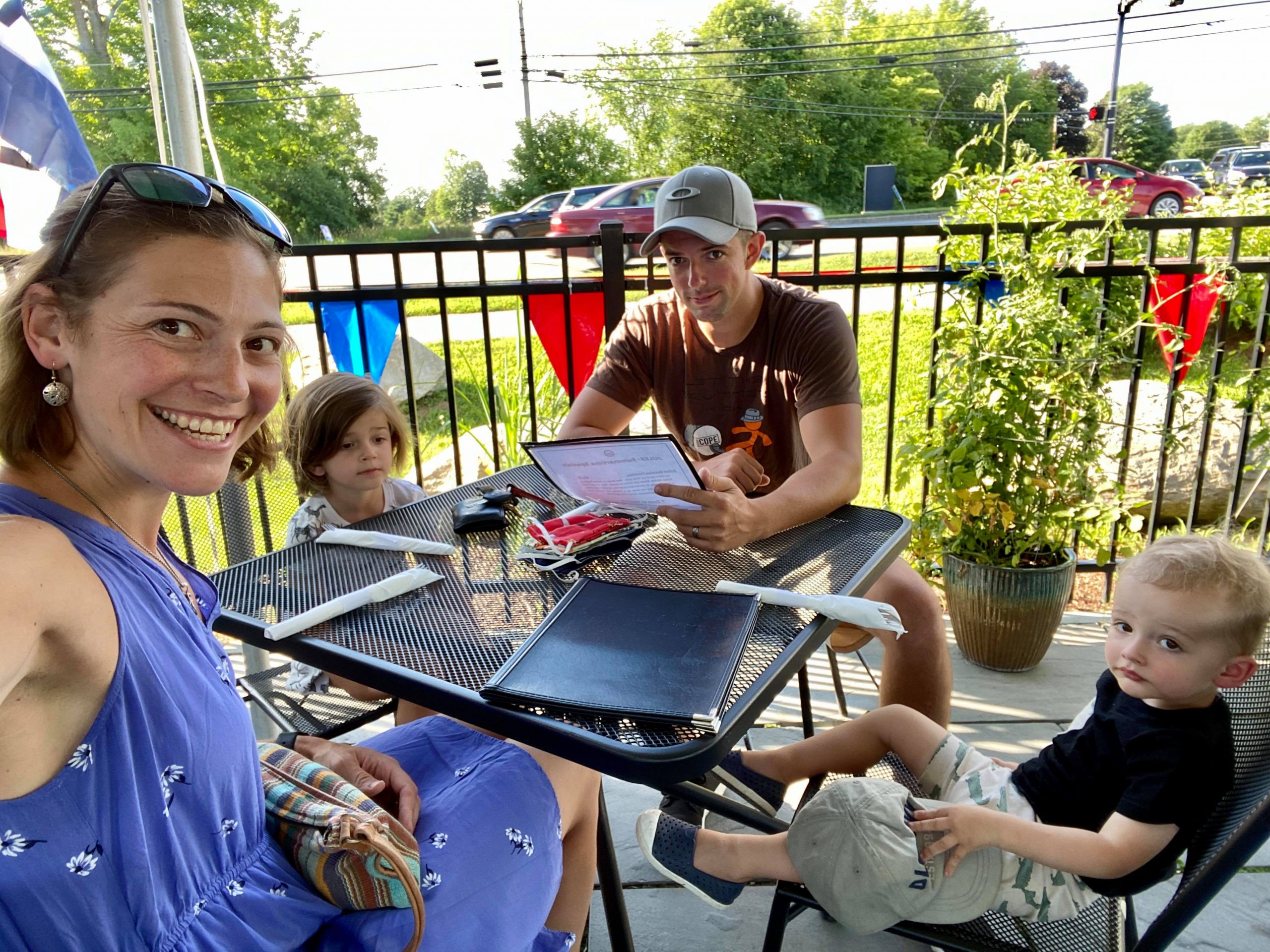 Man reads menu while woman takes family photo
