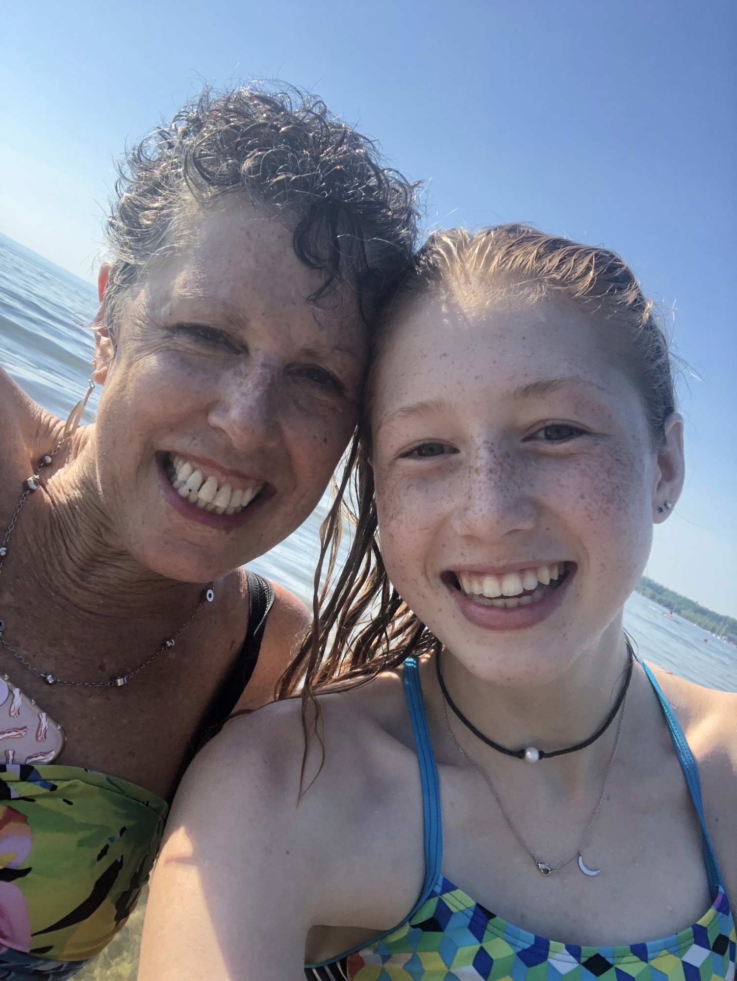 Grandmother and granddaughter hugging after swimming