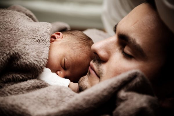 father snuggles infant