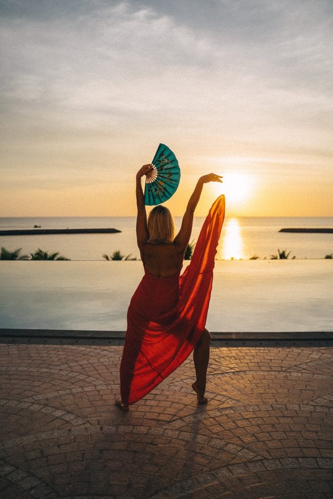 woman posed on the beach with a fan
