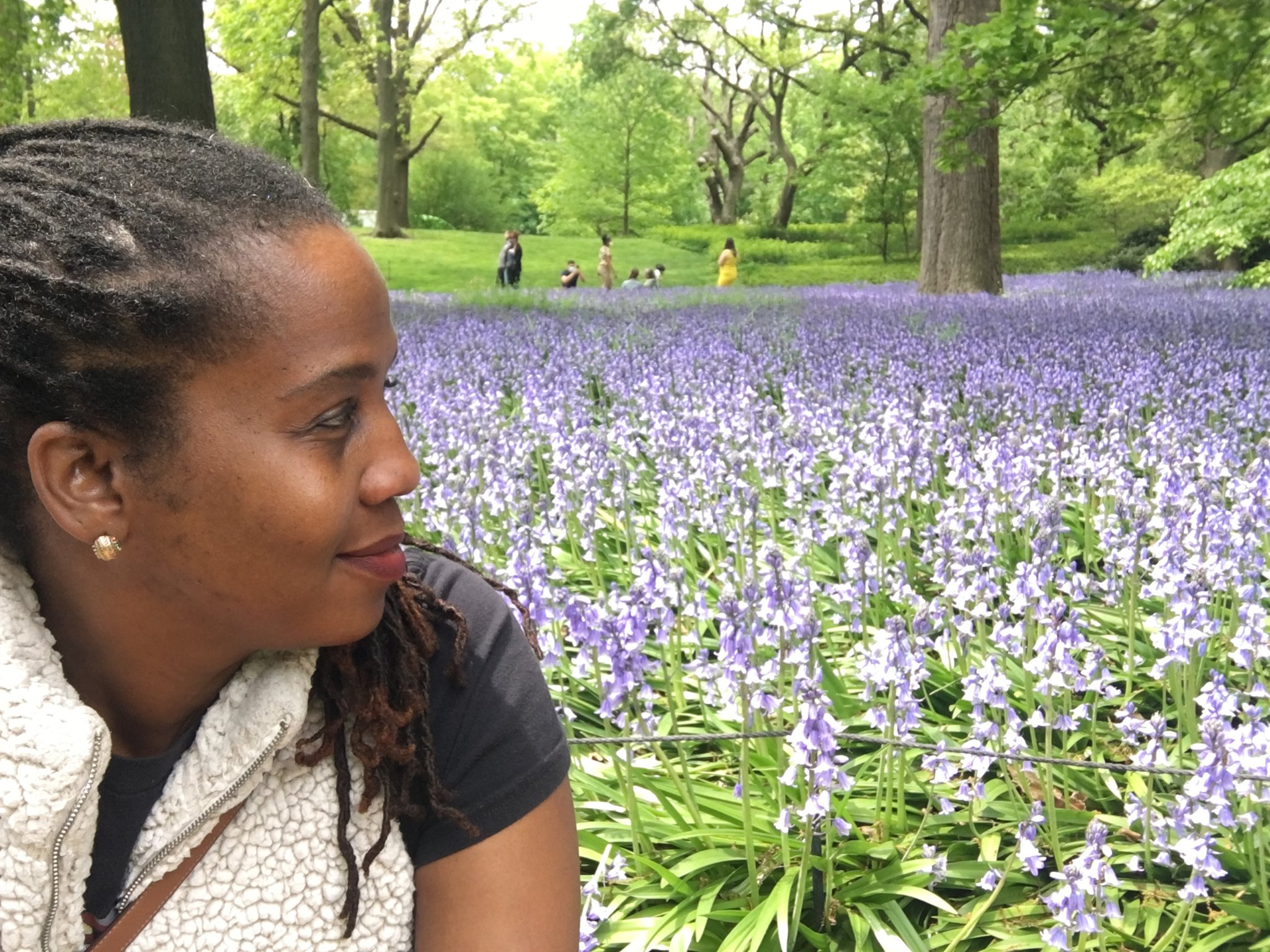 woman smiling in front of a field of purple flowers