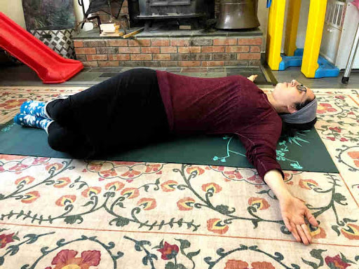 woman lying on her back with her arms straight out on either side