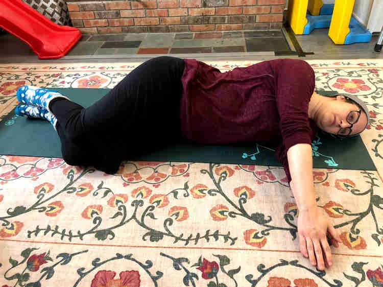 woman lying on her side with her arms forward