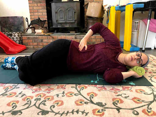 woman lying on her side breathing as a way of exercising after having a baby