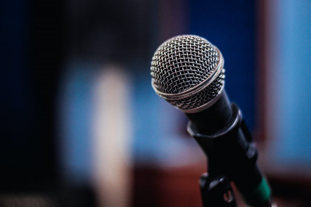 A photograph of a microphone against a blurred background