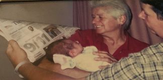 My Son Was Born on September 11 An older woman and young father hold a newborn baby against a newspaper to record the headlines of the day.