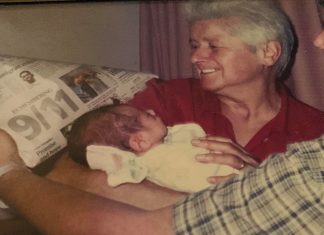 My Son Was Born on September 11 An older woman and young father hold a newborn baby against a newspaper to record the headlines of the day.