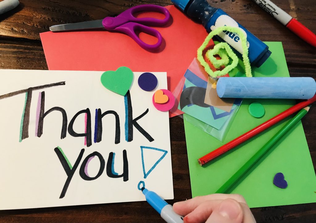A Thank You Card surrounded by craft supplies including chalk, pencils, scissors, stickers, etc.