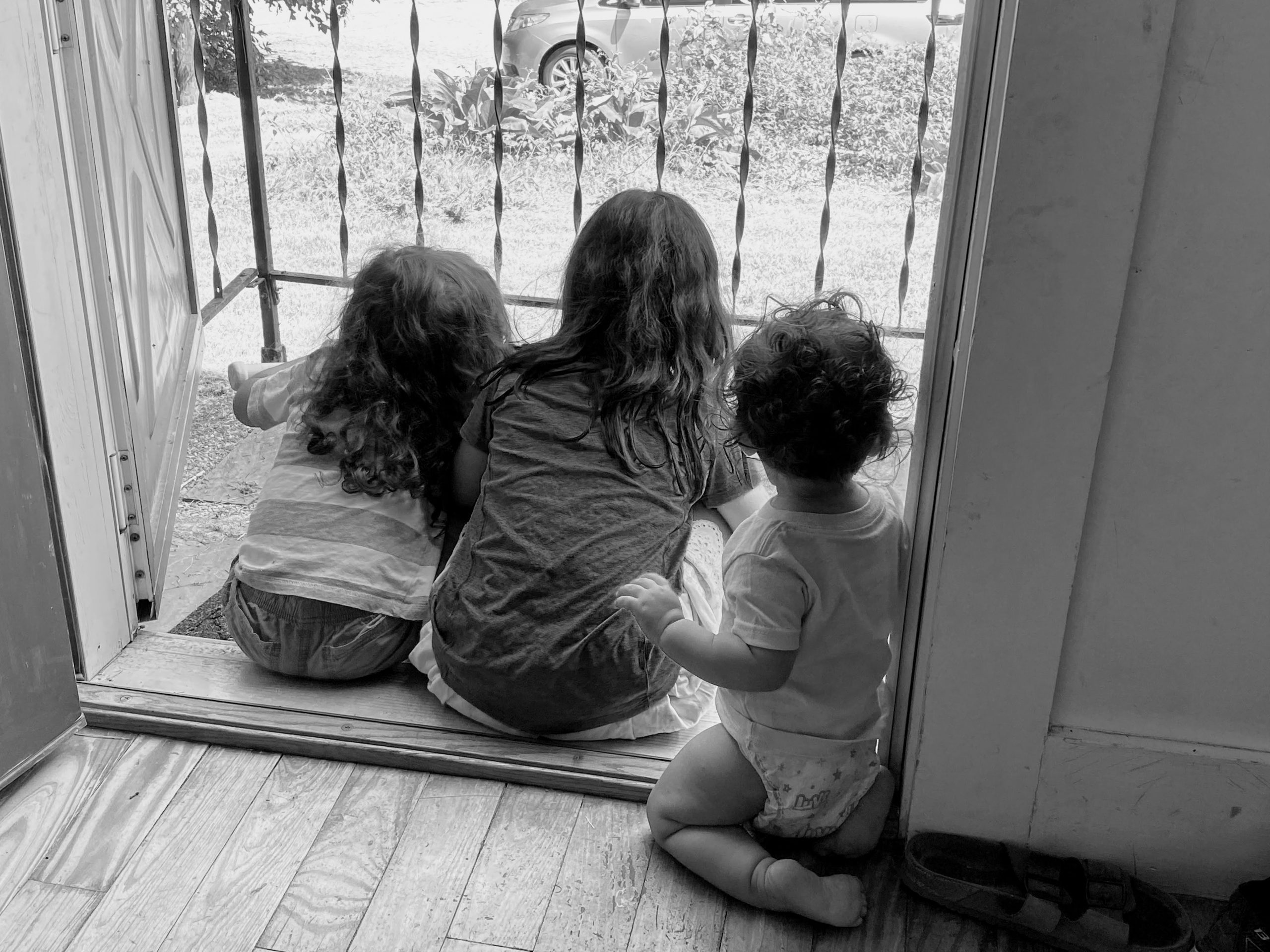 IMG_0085 Children facing away from camera sitting in doorway together