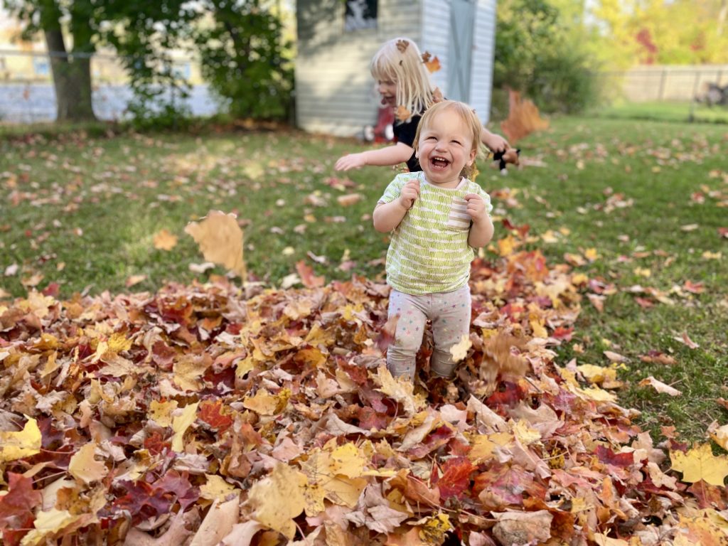 a baby throwing leaves into the air