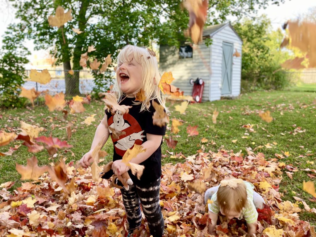 a child throwing leaves in the air