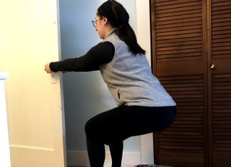 Exercising After Having a Baby, Part 2: 4-8 Weeks Postpartum Woman squats using a door to brace herself